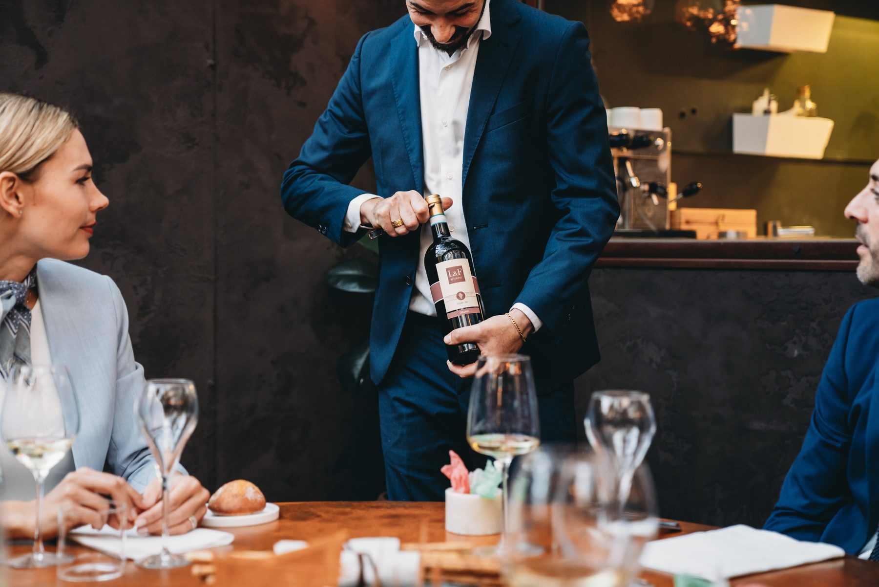 Specialist presenting and pouring a wine for guests at a private dinner